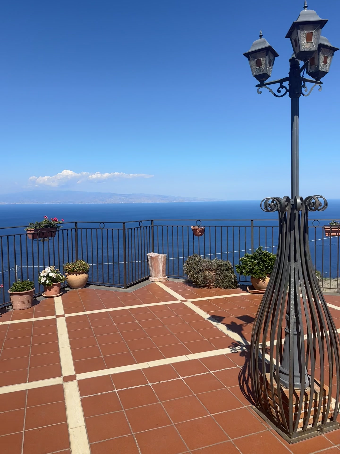 Terrace with flower pots and a blue sea view